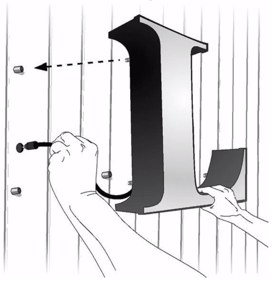 Halo lit channel letter being placed onto wall-mounted stand-off cups
